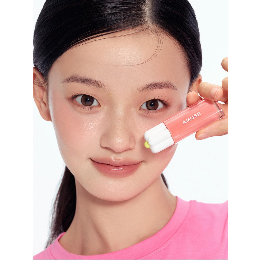 AMUSE Dew Tint original model holding one daisy-cap bottle.